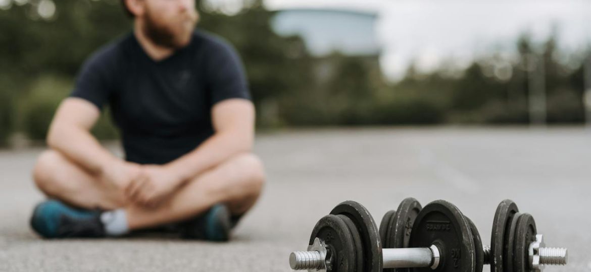 Man sitting on road after working out.